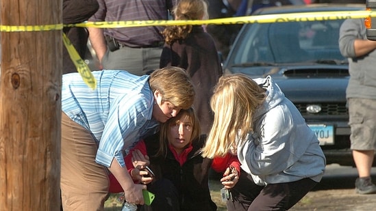 People are comforted near Sandy Hook Elementary School, Dec. 14, 2012 in Newtown, Connecticut (AP Photo/Hearst Connecticut Media, Alex von Kleydorff via AP, File) (AP)