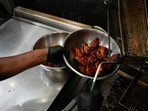 A line cook places chicken wings into a bowl before serving at a barbecue restaurant in Cincinnati. 