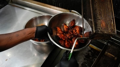 A line cook places chicken wings into a bowl before serving at a barbecue restaurant in Cincinnati. (AP) A line cook places chicken wings into a bowl before serving at a barbecue restaurant in Cincinnati. (AP)