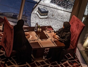 Women sit in a restaurant as Muslim worshippers walk around the Kaaba, Islam's holiest shrine, at the Grand Mosque in Saudi Arabia's holy city of Mecca. (AFP) Women sit in a restaurant as Muslim worshippers walk around the Kaaba, Islam's holiest shrine, at the Grand Mosque in Saudi Arabia's holy city of Mecca. (AFP)