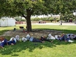 Vendors take rest in the shade of a tree on a hot summer day in New Delhi on Sunday. (PTI)