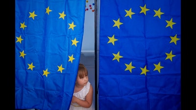 A child peers from a voting cabin during European and local elections in Baleni, Romania, Sunday, June 9 (AP) A child peers from a voting cabin during European and local elections in Baleni, Romania, Sunday, June 9 (AP)