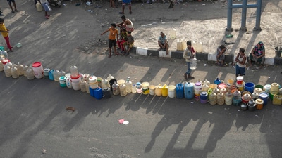 People wait to collect drinking water from a tanker of Delhi Jal Board on a hot summer day as water crisis continues, at a slum in Geeta Colony area, in East Delhi. (PTI)