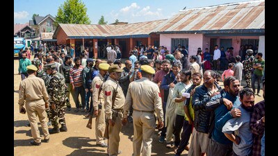 Security personnel stand guard as voters wait in long queues at a polling booth , in Baramulla district of north Kashmir on May 20, (PTI) Security personnel stand guard as voters wait in long queues at a polling booth , in Baramulla district of north Kashmir on May 20, (PTI)