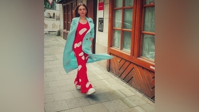 Aditi Rao Hydari wore a co-ord set in bright red shade during her holiday with Siddharth in Munich. The ensemble is adorned in a quirky white pattern. While the blouse features a baggy silhouette, a scoop neckline, and a thigh-length hem, the pants have a straight-leg hem and a relaxed silhouette. She layered the ensemble with a contrasting trench jacket in an aqua-blue hue. It has notch lapel collars, full-length sleeves, an open front, and a full-body length. (Instagram) Aditi Rao Hydari wore a co-ord set in bright red shade during her holiday with Siddharth in Munich. The ensemble is adorned in a quirky white pattern. While the blouse features a baggy silhouette, a scoop neckline, and a thigh-length hem, the pants have a straight-leg hem and a relaxed silhouette. She layered the ensemble with a contrasting trench jacket in an aqua-blue hue. It has notch lapel collars, full-length sleeves, an open front, and a full-body length. (Instagram)