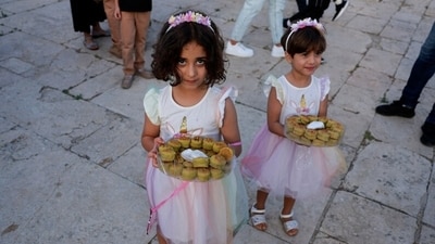At Al-Aqsa compound in Jerusalem's Old City, young girls distributed sweets after the Eid Ul Adha morning prayers. (REUTERS/Ammar Awad) At Al-Aqsa compound in Jerusalem's Old City, young girls distributed sweets after the Eid Ul Adha morning prayers. (REUTERS/Ammar Awad)
