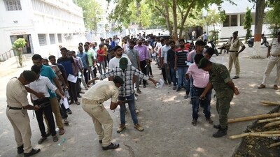 Security personnels frisk aspirants outside an examination centre in Patna before they enter the exam hall ( Photo by Santosh Kumar) Security personnels frisk aspirants outside an examination centre in Patna before they enter the exam hall ( Photo by Santosh Kumar)