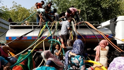 Residents use pipes to fill their containers with drinking water from a water tanker during a hot day in New Delhi, India (REUTERS)