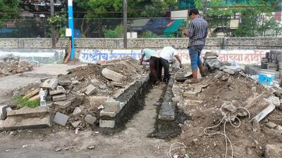 The road department has broken footpath at Shivaji Chowk on Satara Road to create channel for water flow to nearby nullahs. (HT PHOTO)