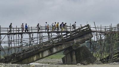 Villagers use a temporary bamboo bridge to cross a river after the bridge over it washed away in flood water at Subankhata village in Assam’s Baksa district onSunday. (PTI) Villagers use a temporary bamboo bridge to cross a river after the bridge over it washed away in flood water at Subankhata village in Assam’s Baksa district onSunday. (PTI)