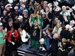Boston Celtics forward Jayson Tatum (0) celebrates with the trophy on the podium after defeating the Dallas Mavericks in the 2024 NBA Finals