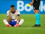 Kylian Mbappe of France sits on the pitch, hand over his bloody nose, as the referee holds the yellow card, during a Group D match against Austria Kylian Mbappe of France sits on the pitch, hand over his bloody nose, as the referee holds the yellow card, during a Group D match against Austria