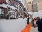 Tunisians attend the inauguration of the '1001 Bricks Fresco', a participatory artwork by more than 500 inhabitants of Tunis led by Swiss artist Anne Francey, illustrating the diversity of the city, with the bas relief installed on the edge of the medina, the old town listed by UNESCO, in the capital's El-Hafsia district on June 7, 2024. The installation showcases the talents of "invisible" creators, including art students, people with disabilities and school dropouts. 