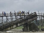 Villagers use a temporary bamboo bridge to cross a river after the bridge over it washed away in flood water at Subankhata village in Assam’s Baksa district on Sunday. (PTI) Villagers use a temporary bamboo bridge to cross a river after the bridge over it washed away in flood water at Subankhata village in Assam’s Baksa district on Sunday. (PTI)