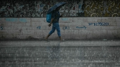 A man carrying an umbrella walks along a street during rainfall in Chennai. (AFP) A man carrying an umbrella walks along a street during rainfall in Chennai. (AFP)