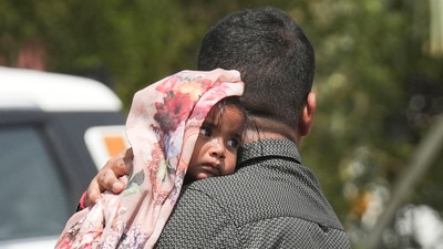 A man covers a child with a scarf during a heatwave, in New Delhi on Saturday, June 15. (PTI) A man covers a child with a scarf during a heatwave, in New Delhi on Saturday, June 15. (PTI)