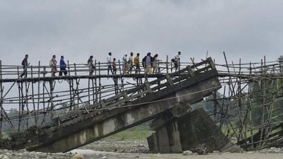 Villagers use a temporary bamboo bridge to cross a river after the bridge over it washed away in flood water at Subankhata village in Assam’s Baksa district on Sunday. (PTI) Villagers use a temporary bamboo bridge to cross a river after the bridge over it washed away in flood water at Subankhata village in Assam’s Baksa district on Sunday. (PTI)