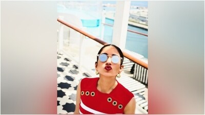 Radhika's sleeveless red blouse features a round neckline, a ribbed design, metal eyelets embellished on the bodice, horizontal white stripes, and a snug fit. The bride-to-be tucked the blouse inside her pants to add some definition to her ensemble and highlight her svelte frame. (Instagram) Radhika's sleeveless red blouse features a round neckline, a ribbed design, metal eyelets embellished on the bodice, horizontal white stripes, and a snug fit. The bride-to-be tucked the blouse inside her pants to add some definition to her ensemble and highlight her svelte frame. (Instagram)