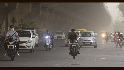 Commuters make their way amid a dust storm in Ludhiana on Wednesday. (Manish/HT)