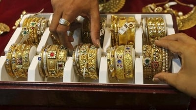 A salesman helps a customer to select gold bangles at a jewellry showroom in Mumbai (Reuters) A salesman helps a customer to select gold bangles at a jewellry showroom in Mumbai (Reuters)