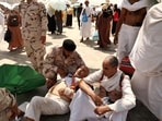 A man effected by the scorching heat is helped by a member of the Saudi security forces as Muslim pilgrims arrive to perform the symbolic 'stoning of the devil' ritual as part of the hajj pilgrimage in Mina, near Saudi Arabia's holy city of Mecca, (Photo by Fadel Senna / AFP)