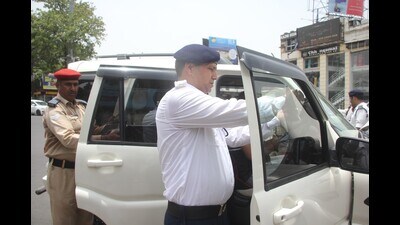 Traffic police removing black film from the window of a car. (HT)