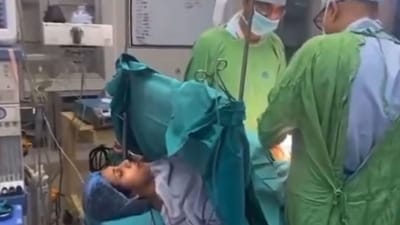 Doctors performing C-section surgery on the woman as she sings a Lord Krishna bhajan. (X/@fenilkothari) Doctors performing C-section surgery on the woman as she sings a Lord Krishna bhajan. (X/@fenilkothari)