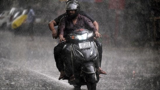 Commuters travel during light rain in Noida, (Sunil Ghosh /HT file)