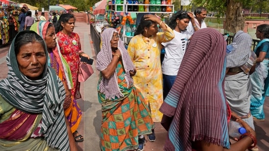 Local tourists exhausted with the heat wave buy drinking water bottles, in New Delhi, India, Tuesday, June 18, 2024. India's capital New Delhi remains in the grip of a scorching heat wave which according to India's weather agency, is among the longest heat spells the city has faced in recent times. (AP Photo/Manish Swarup)