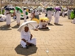 Muslim pilgrims use umbrellas to shade themselves from the sun as they arrive at the base of Mount Arafat, also known as Jabal al-Rahma or Mount of Mercy, during the annual hajj pilgrimage on June 15, 2024.