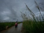 A commuter rides on a scooter as monsoon clouds hover over the sky on the outskirts of Guwahati, India, Thursday, June 20, 2024 (AP Photo/Anupam Nath)(AP)