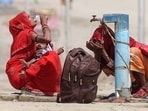 Women quench their thirst with tap water on a hot summer afternoon during an intense heatwave in Prayagraj.(AFP Photo)