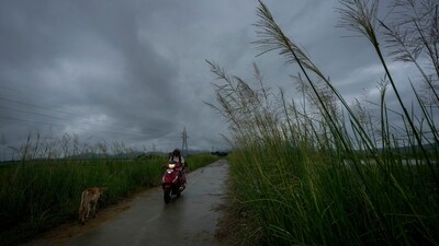 A commuter rides on a scooter as monsoon clouds hover over the sky on the outskirts of Guwahati, India, Thursday, June 20, 2024 (AP Photo/Anupam Nath) (AP) A commuter rides on a scooter as monsoon clouds hover over the sky on the outskirts of Guwahati, India, Thursday, June 20, 2024 (AP Photo/Anupam Nath) (AP)