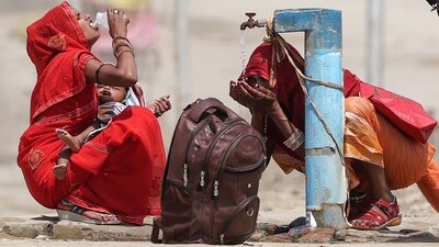 Women quench their thirst with tap water on a hot summer afternoon during an intense heatwave in Prayagraj. (AFP Photo)