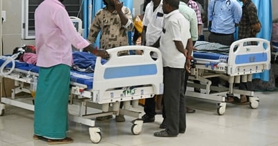 Family members stand next to a patient admitted to a government hospital after consuming toxic alcohol in Kallakurichi district of India's Tamil Nadu state on June 20, 2024.