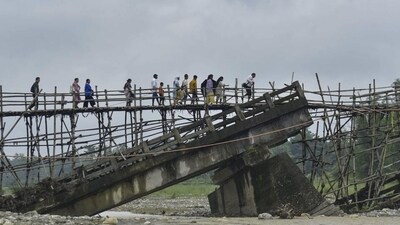 Villagers use a temporary bamboo bridge to cross a river after the bridge over it washed away in flood water at Subankhata village in Assam’s Baksa district on Sunday. (PTI) Villagers use a temporary bamboo bridge to cross a river after the bridge over it washed away in flood water at Subankhata village in Assam’s Baksa district on Sunday. (PTI)