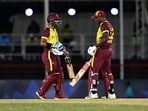 West Indies' captain Rovman Powell (R) and West Indies' wicketkeeper Nicholas Pooran (L) meet after Powell hit a six during the ICC men's Twenty20 World Cup 2024 Super Eight cricket match between England and the West Indies