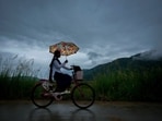 A school girl with an umbrella rides on her bicycle to school during the monsoon rain as clouds hover over the sky on the outskirts of Guwahati on June 20. A school girl with an umbrella rides on her bicycle to school during the monsoon rain as clouds hover over the sky on the outskirts of Guwahati on June 20.