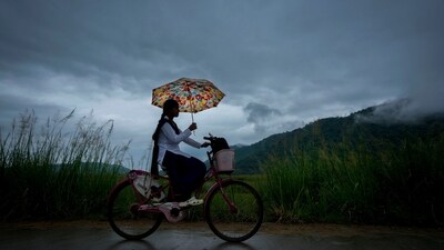 A school girl with an umbrella rides on her bicycle to school during the monsoon rain as clouds hover over the sky on the outskirts of Guwahati on June 20. (AP) A school girl with an umbrella rides on her bicycle to school during the monsoon rain as clouds hover over the sky on the outskirts of Guwahati on June 20. (AP)