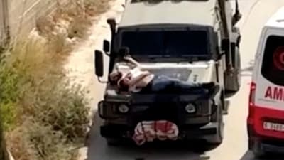 Israeli army straps Palestinian on military jeep during raid in Jenin, in this screengrab from a video, in the Israeli-occupied West Bank, June 22, 2024. (REUTERS)