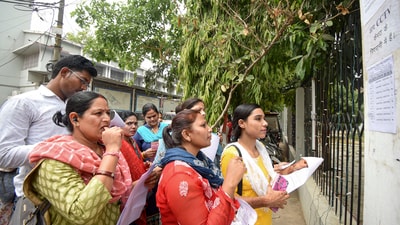 Aspirants search their roll numbers for seats before entering an examination center to appear in the UGC-NET exam. (PTI) Aspirants search their roll numbers for seats before entering an examination center to appear in the UGC-NET exam. (PTI)