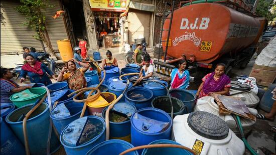 People line up to get their fill of water from a tanker at Baljeet Nagar. (Sanchit Khanna/HT Photo)
