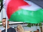 A person holds a Palestine flag as people participate in a 'Climate Justice Means Free Palestine!' rally outside of the Citibank headquarters on June 18, 2024 in New York City. Michael M. Santiago/Getty Images/AFP (Photo by Michael M. Santiago / GETTY IMAGES NORTH AMERICA / Getty Images via AFP) A person holds a Palestine flag as people participate in a 'Climate Justice Means Free Palestine!' rally outside of the Citibank headquarters on June 18, 2024 in New York City. Michael M. Santiago/Getty Images/AFP (Photo by Michael M. Santiago / GETTY IMAGES NORTH AMERICA / Getty Images via AFP)