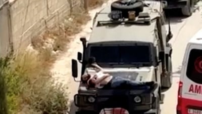 Israeli army straps Palestinian on military jeep during a raid in West Bank's Jenin, on June 22, 2024.