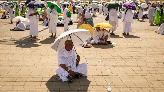 Muslim pilgrims use umbrellas to shade themselves from the sun as they arrive at the base of Mount Arafat, also known as Jabal al-Rahma or Mount of Mercy, during the annual hajj pilgrimage on June 15, 2024. (AFP)