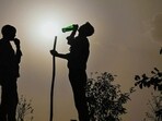A guard drinks water while being silhouetted against the hot summer sun, at Ashram Flyover in New Delhi, India, on Wednesday. (Hindustan Times) A guard drinks water while being silhouetted against the hot summer sun, at Ashram Flyover in New Delhi, India, on Wednesday. (Hindustan Times)