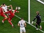 Denmark's Victor Kristiansen, left, and Kasper Dolberg (12) and Serbia's Andrija Zivkovic (14) challenge for the ball during a Group C match between Denmark and Serbia at the Euro 2024 soccer tournament in Munich