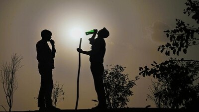 A guard drinks water while being silhouetted against the hot summer sun, at Ashram Flyover in New Delhi, India, on Wednesday. (Hindustan Times) A guard drinks water while being silhouetted against the hot summer sun, at Ashram Flyover in New Delhi, India, on Wednesday. (Hindustan Times)