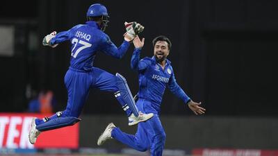 Afghanistan's captain Rashid Khan celebrates with teammate Mohammad Ishaq during their T20 World Cup match against Bangladesh in Kingstown on Monday. (AP) Afghanistan's captain Rashid Khan celebrates with teammate Mohammad Ishaq during their T20 World Cup match against Bangladesh in Kingstown on Monday. (AP)
