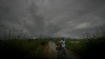 FILE - A farmer carries a sack of paddy on his bicycle during monsoon rains as clouds hover over the sky on the outskirts of Guwahati, India, June 20, 2024. Human-caused climate change is making rainfall more unpredictable and erratic, which makes it difficult for farmers to plant, grow and harvest crops on their rain-fed fields. (AP Photo/Anupam Nath, File) (AP) FILE - A farmer carries a sack of paddy on his bicycle during monsoon rains as clouds hover over the sky on the outskirts of Guwahati, India, June 20, 2024. Human-caused climate change is making rainfall more unpredictable and erratic, which makes it difficult for farmers to plant, grow and harvest crops on their rain-fed fields. (AP Photo/Anupam Nath, File) (AP)